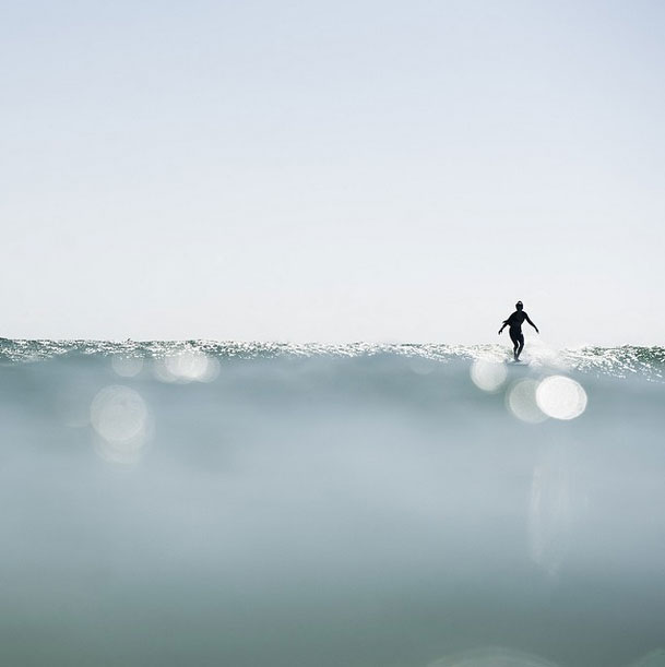 An image of a woman surfs down a wave