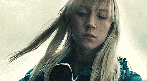 A gif of Saoirse Ronan looking down at something off frame from the film How I Live Now