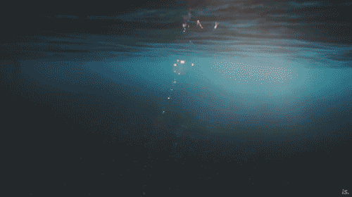 A gif of a camera view moving from underwater to above water revealing the mountains of Fiji