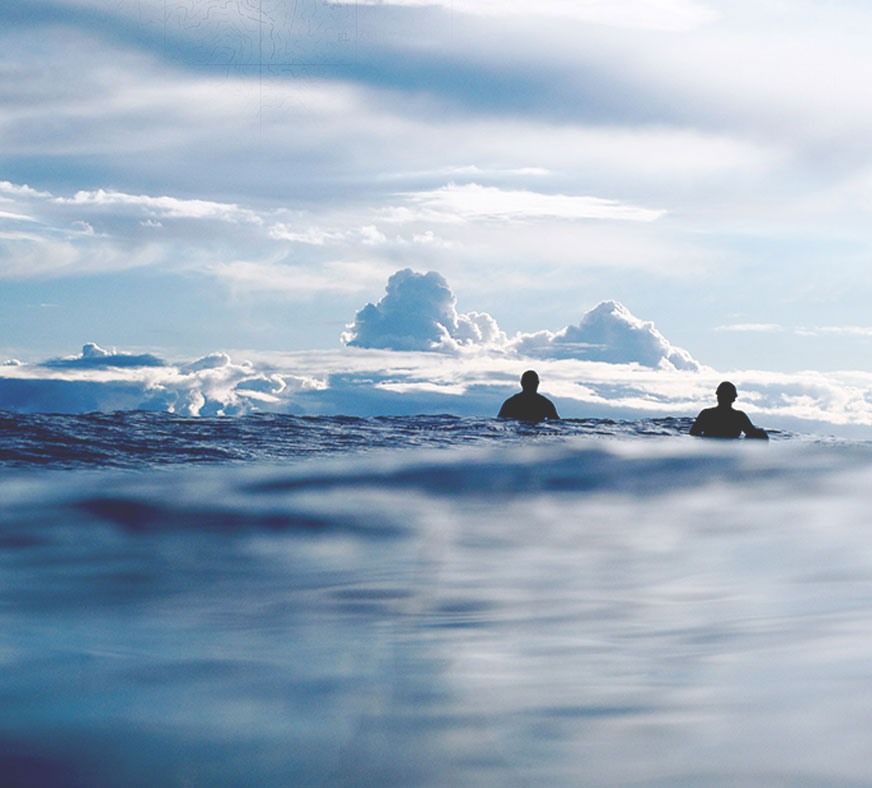 Two surfers sit on their boards in a photo by Morgan Maassen